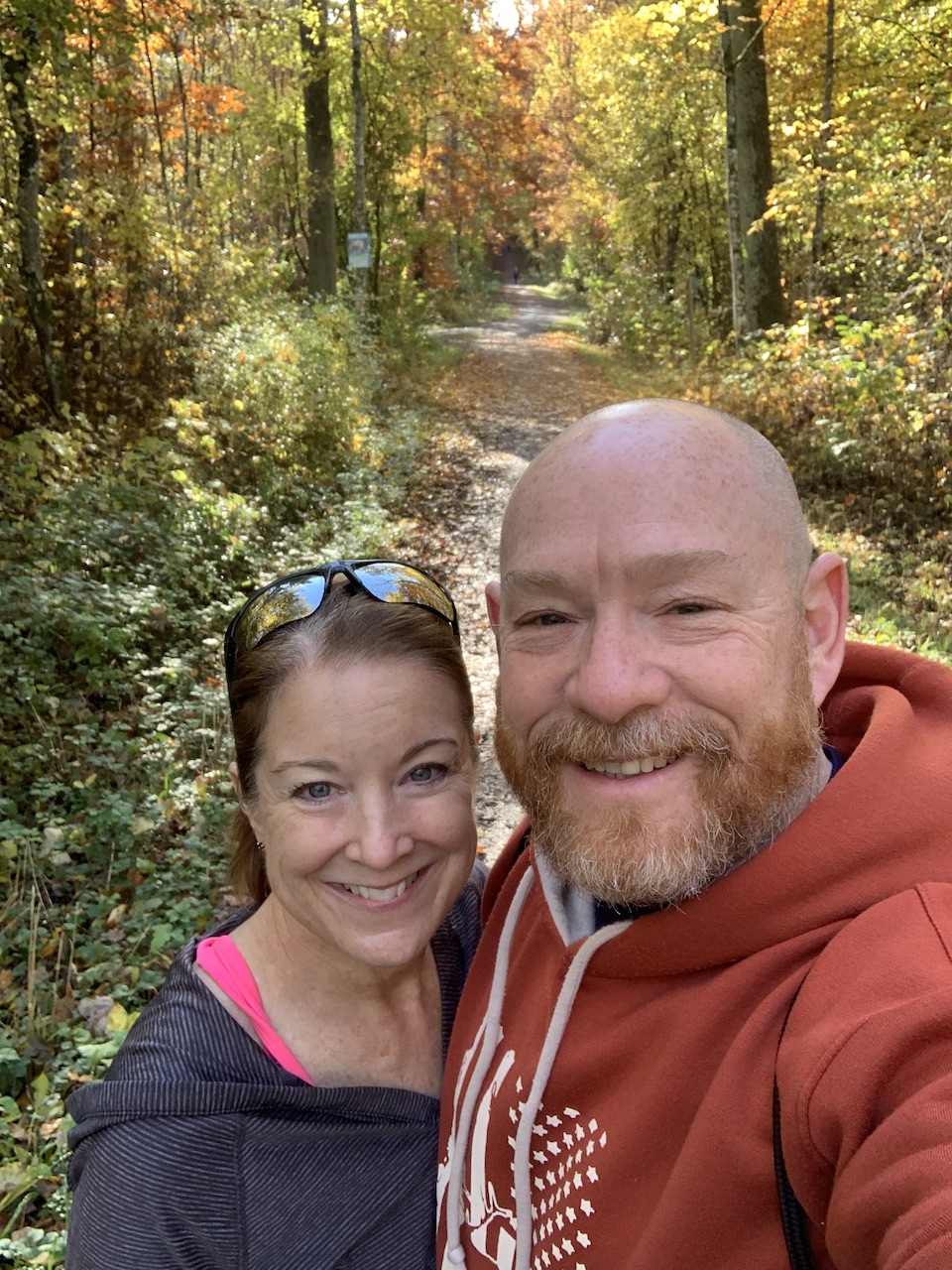 Rob and Barbara on a walk in the woods in the autumn with yellow and orange leaves on the trees